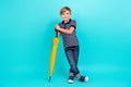 Full size photo of cool little boy hold umbrella wear t-shirt jeans sneakers isolated on teal background Royalty Free Stock Photo