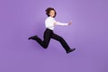 Full size photo of cool little brunet boy jump fight wear shirt trousers sneakers isolated on purple background Royalty Free Stock Photo