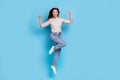 Full size photo of cool young lady jump index herself wear shirt jeans boots isolated on blue color background Royalty Free Stock Photo