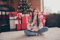 Full size photo of dream young lady write list sit near present tree wear sweater jeans socks christmas at home