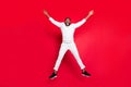 Full size photo of excited dark skin handsome guy jumping high rejoicing having best x-mas party time wear white sweater