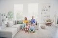 Full size photo of family two little kids sit floor mommy daddy couch watch tv channel with remote control in house Royalty Free Stock Photo