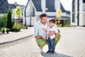 Full size photo of father and son on street speak talk communicate conversation dad sits supports son outside outdoor