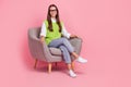 Full size photo of friendly professional psychology specialist woman waistcoat jeans sit on armchair on pink