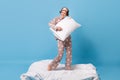 Full size photo of funky happy woman play pillow imagine guitar stank blanket barefoot wear pajama on blue