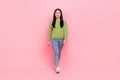 Full size photo of funky millennial lady go wear sweatshirt jeans sneakers isolated on pink color background