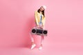 Full size photo of funky pretty girl hold boombox wear cap jacket trousers sneakers isolated on pastel pink color