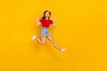 Full size photo of funky teen girl jump wave wear t-shirt hairband skirt sneakers isolated on yellow background Royalty Free Stock Photo