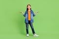 Full size photo of funny preteen girl hold hands wear shirt jeans hairband shoes isolated on green background Royalty Free Stock Photo