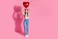 Full size photo of good mood girl dressed colorful blouse jeans pants hodling heart bubble over head isolated on pink