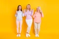 Full size photo of happy victorious women generation raise fists celebrate wear casual clothes isolated on yellow color