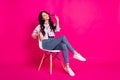 Full size photo of impressed brunette nice lady sit look empty space wear jacket jeans sneakers isolated on pink