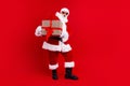 Full size photo of impressed funny grandfather wear stylish santa costume holding stripped gift box isolated on red
