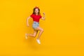 Full size photo of impressed teen girl run wear t-shirt hairband skirt footwear isolated on yellow background Royalty Free Stock Photo