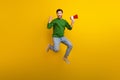 Full size photo of jumping guy fist up hooray holding megaphone bullhorn announce fist his losung win isolated on yellow Royalty Free Stock Photo