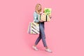 Full size photo of lovely young woman hold pile present boxes walk dressed stylish flower print garment isolated on pink Royalty Free Stock Photo