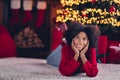 Full size photo of minded cute positive girl laying floor hands touch cheeks imagine inspiration christmastime indoors Royalty Free Stock Photo