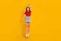 Full size photo of nice little girl jump wear red t-shirt hairband jeans skirt shoes isolated on yellow background Royalty Free Stock Photo