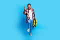 Full size photo of nice young man suitcase running raise arm catch wear shirt isolated on blue color background Royalty Free Stock Photo