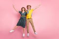 Full size photo of optimistic funny couple jump wear colorful clothes isolated on pastel pink background Royalty Free Stock Photo