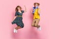 Full size photo of optimistic funny couple jump wear colorful clothes isolated on pastel pink background Royalty Free Stock Photo