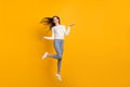Full size photo of optimistic girl jump wear sweater jeans sneakers isolated on yellow color background Royalty Free Stock Photo