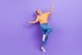Full size photo of optimistic gorgeous nice girl dressed sneakers denim pants dancing having fun isolated on purple Royalty Free Stock Photo
