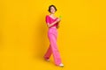 Full size photo of optimistic lovely nice girl wear knit top pink pants holding smartphone walking isolated on yellow Royalty Free Stock Photo