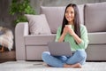 Full size photo of positive asian girl work remote laptop dream dreamy weekend hold mug beverage sit floor carpet legs