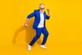 Full size photo of positive grey beard elder man dance wear spectacles blue jacket isolated on yellow background