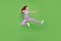 Full size photo of positive happy young woman jump up look empty space fighter isolated on green color background