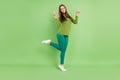 Full size photo of positive nice pretty young woman make v-signs smile cool isolated on green color background