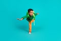 Full size photo of positive small boy with rucksack wear green hoodie hold arms like wings have fun on