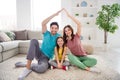 Full size photo of positive three people mommy daddy small kid girl make hands roof enjoy loan house sit comfort carpet Royalty Free Stock Photo