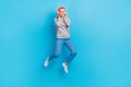 Full size photo of pretty carefree girl jumping hands touch headphones empty space isolated on blue color background Royalty Free Stock Photo