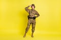 Full size photo of pretty friendly lady put hand on waist touch cap  on yellow color background Royalty Free Stock Photo