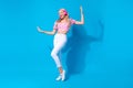 Full size photo of pretty young girl headphones dance music dressed stylish pink cherry print clothes isolated on blue Royalty Free Stock Photo