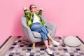 Full size photo of relaxed person dressed plaid shirt look empty space arms behind head sit on armchair on pink