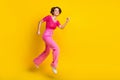 Full size photo of satisfied friendly girl wear knit top pink pants running shopping empty space isolated on yellow Royalty Free Stock Photo