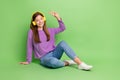 Full size photo of satisfied optimistic girl with long hairdo dressed jeans headphones showing v-sign isolated on green Royalty Free Stock Photo