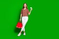 Full size photo of smart beautiful teenager holding shopping bags demonstrate debit card in arm isolated on green color