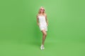 Full size photo of smiling beautiful woman wear gorgeous white overall enjoy summer isolated on green color background Royalty Free Stock Photo