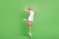 Full size photo of smiling gorgeous girl jumping dancing energetic party club isolated on green color background