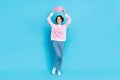 Full size photo of sweet positive girl hold pink paper heart above head healthcare promotion isolated on blue color Royalty Free Stock Photo