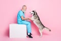 Full size photo of veterinarian man enjoy health care siberian husky doggy isolated on pastel color background