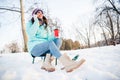 Full size photo of young beautiful charming positive girl drinking coffee talking on phone sit sledge in winter park Royalty Free Stock Photo