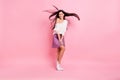 Full size photo of young beautiful positive flirty coquettish girl with flying hair dancing on pink color