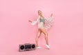 Full size photo of young blond lady dance near boombox wear top cape shorts footwear isolated on pink background Royalty Free Stock Photo