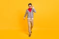 Full size photo of young confident man happy positive smile go walk step hand touch glasses isolated over yellow color