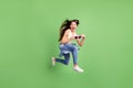 Full size photo of young crazy excited funky little girl jumping hold funky sunglass screaming isolated on green color